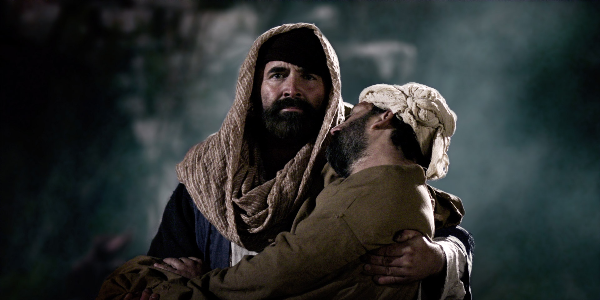 A man carries an injured man through a fog