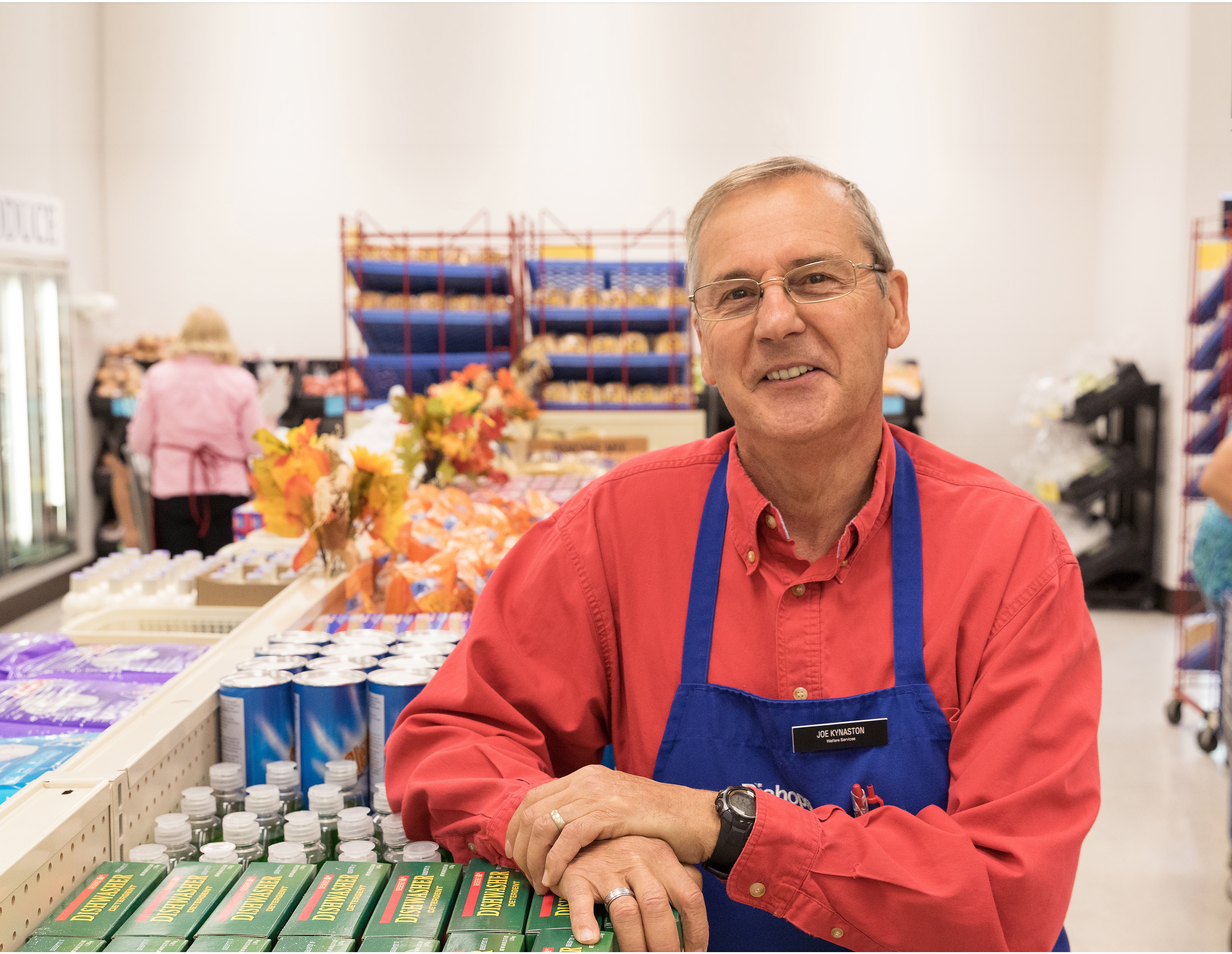 A senior missionary standing in an isle of a Bishops' Storehouse.